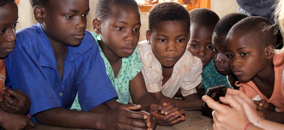 A small group of Malawian girls learning how to use a handheld player